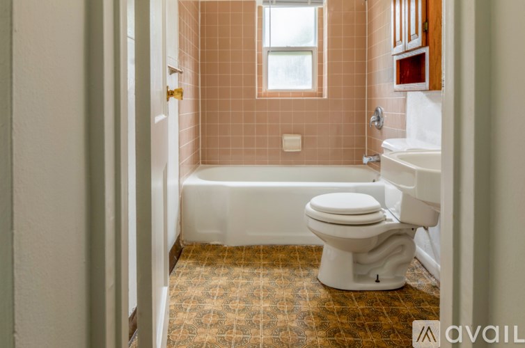 A bathroom with a toilet, tub, and sink.