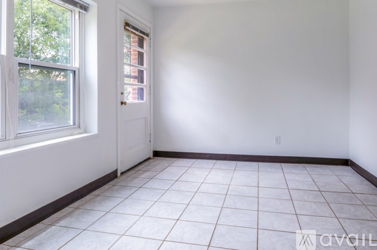 A room with a window and a door is available for rent.