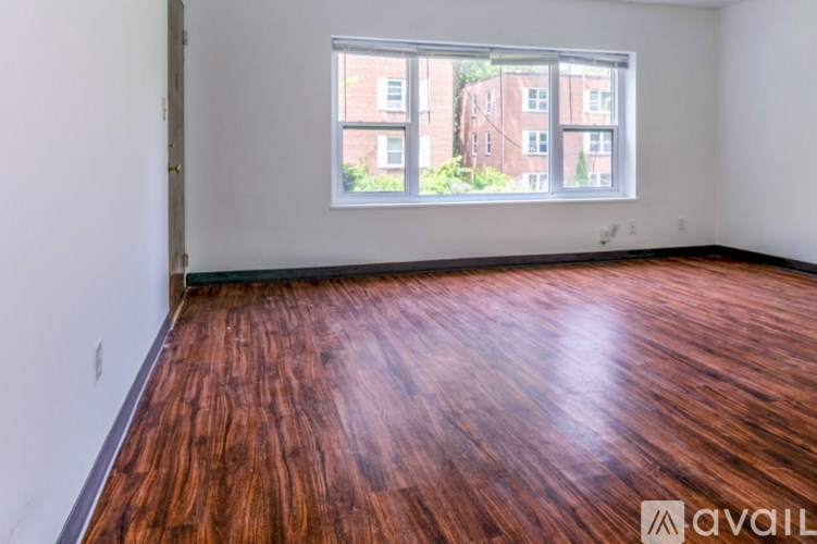 A room with wooden flooring and a large window.