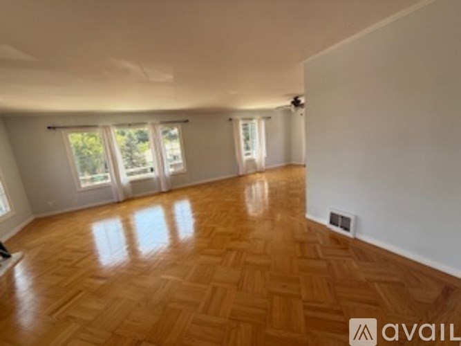 A room with wooden flooring and white walls.