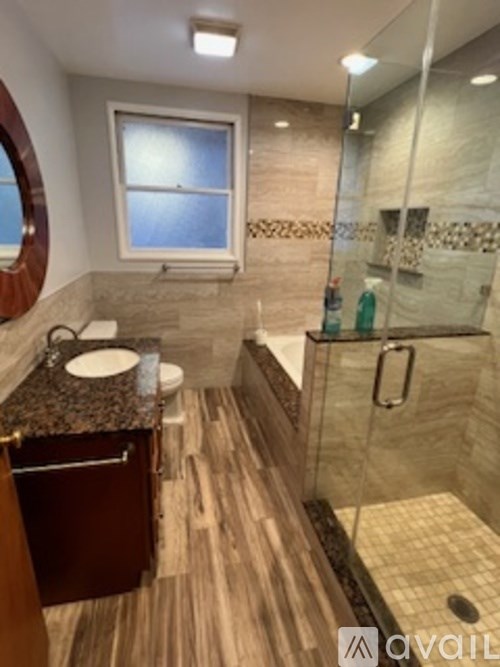 A bathroom with a marble countertop and a walk-in shower.