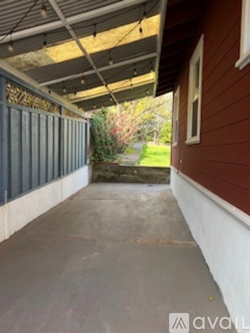 A patio area with a concrete floor and a wooden wall.