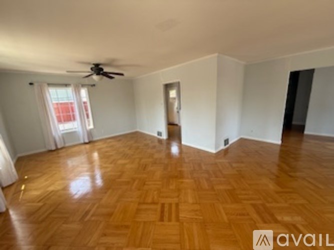 A room with wooden flooring and a ceiling fan.