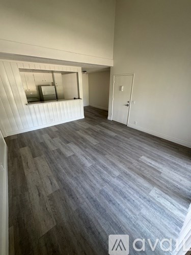 A room with wooden flooring and white walls.
