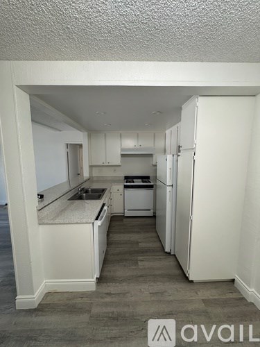 A kitchen with white appliances and cabinets.