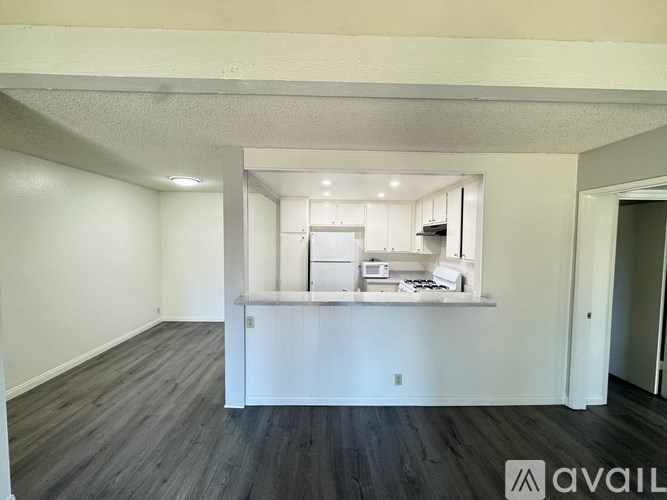 A room with wooden flooring and a window with blinds.