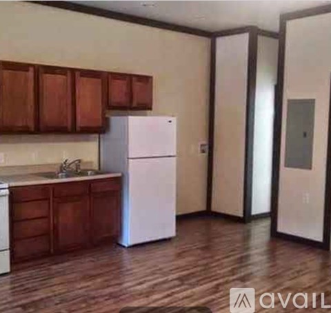 A kitchen with wooden cabinets and a white refrigerator.