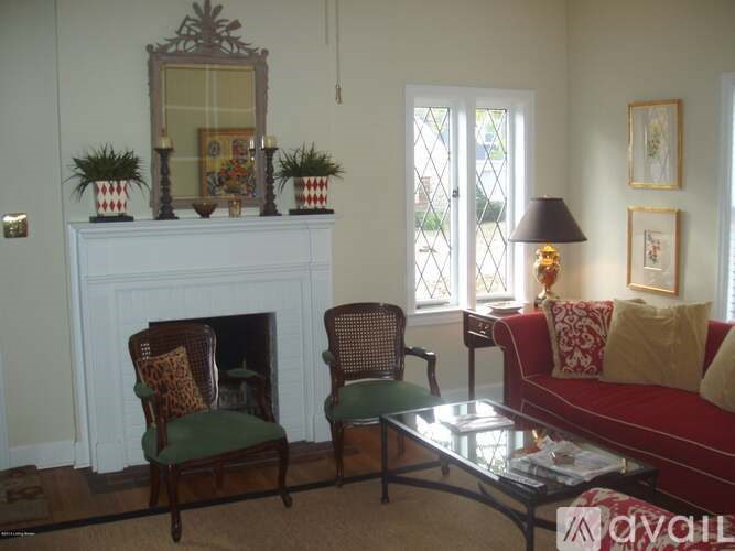 A living room with a fireplace, two chairs, a couch, and a coffee table.