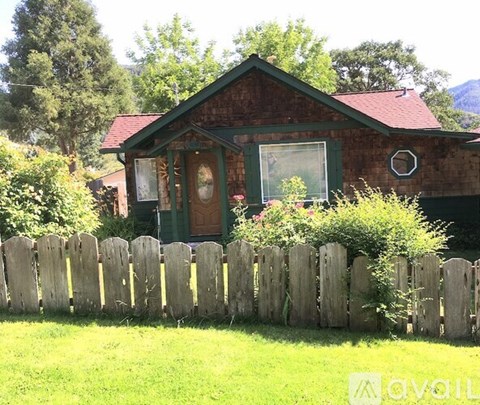 A house with a green door and a wooden fence in front.