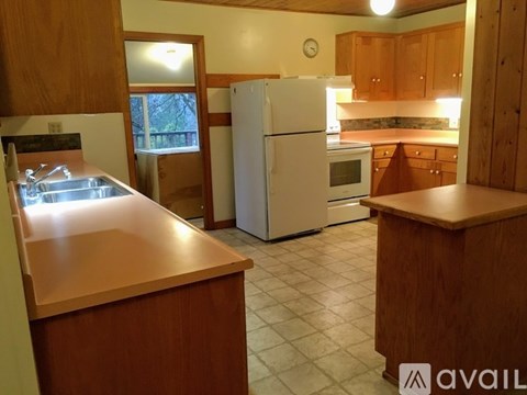 A kitchen with wooden cabinets and a white refrigerator.