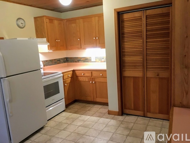 A kitchen with wooden cabinets and a white refrigerator.