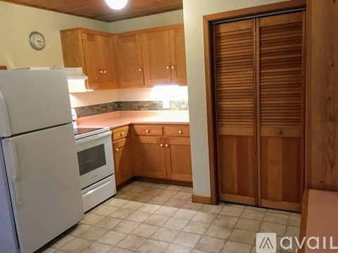 A kitchen with wooden cabinets and a white refrigerator.