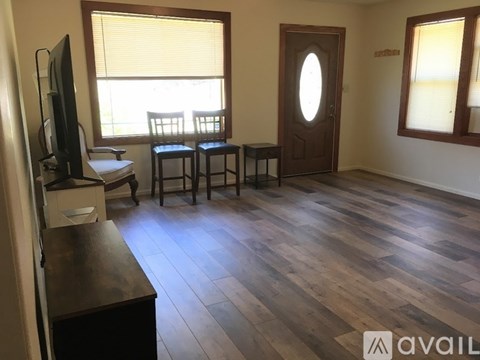 A living room with a wooden floor and a television.