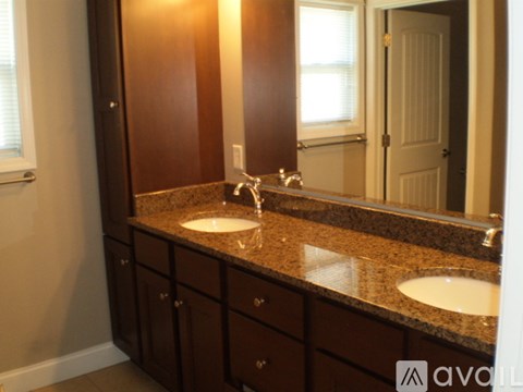 A bathroom with two sinks and a large mirror.