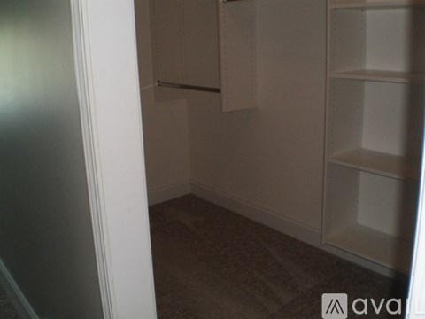 A white door is open to a room with a carpeted floor and a white cabinet.