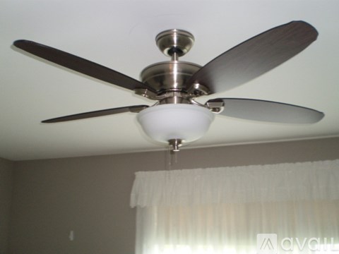 A silver ceiling fan with five blades and a light fixture hangs from the ceiling.