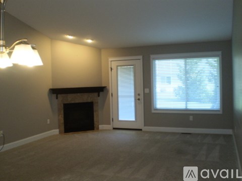 A living room with a fireplace and a door leading to a balcony.