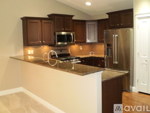 A kitchen with brown cabinets and a granite countertop.