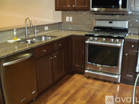 A kitchen with brown cabinets and stainless steel appliances.