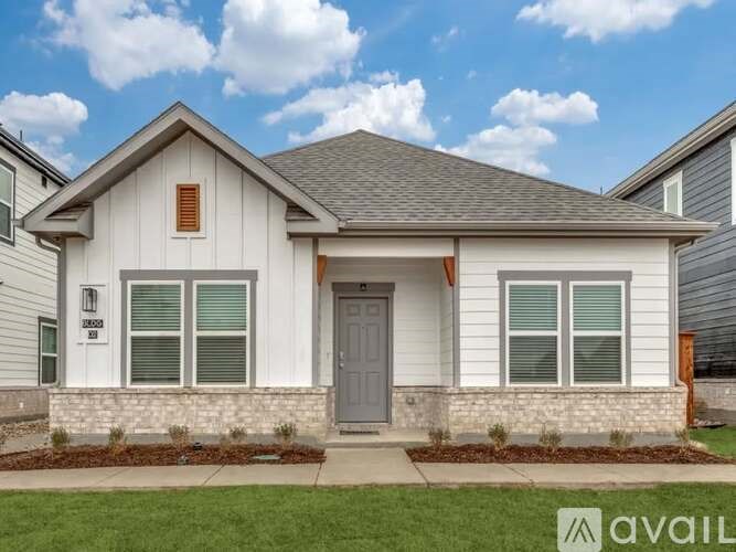 A house with a grey front door and windows is for sale.