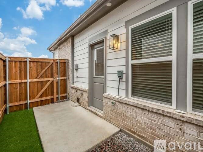 A house with a grey door and a wooden fence.