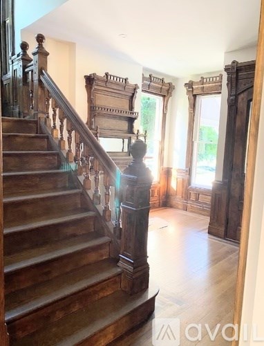 A staircase with a wooden banister and steps leads up to a balcony.