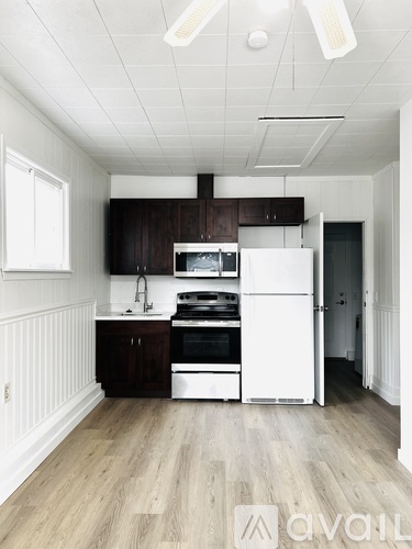 A kitchen with white appliances and wooden cabinets.