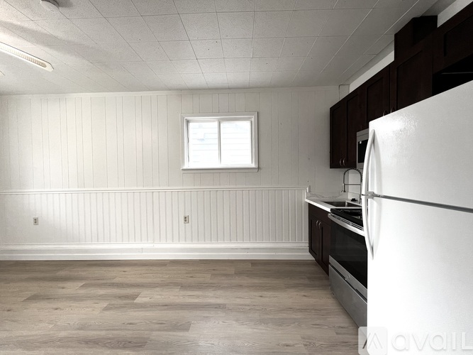 A kitchen with a white refrigerator and wooden cabinets.