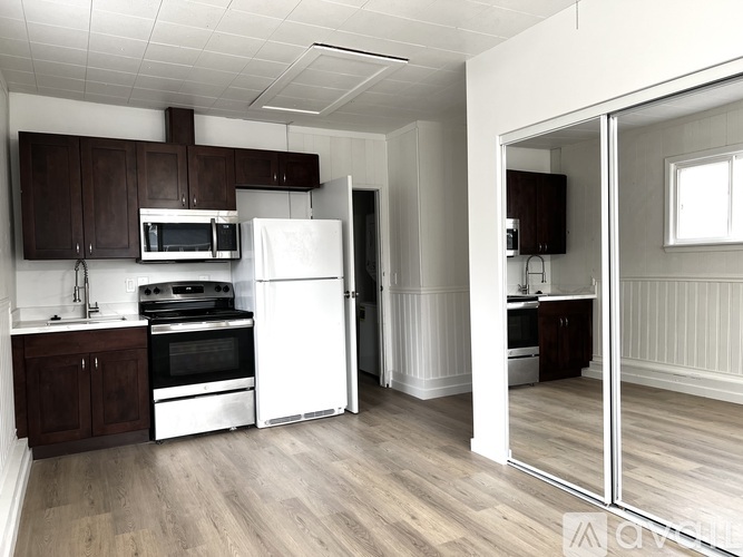 A kitchen with white appliances and wooden cabinets.