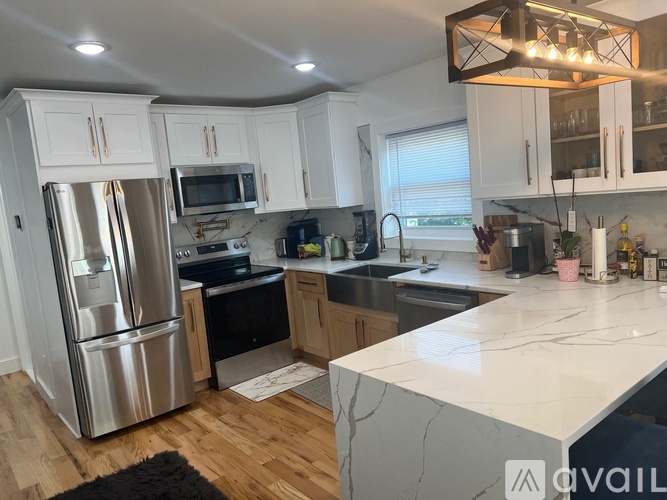 A kitchen with white cabinets and a stainless steel refrigerator.
