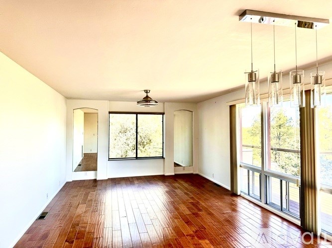 A room with wooden floors and a large window.