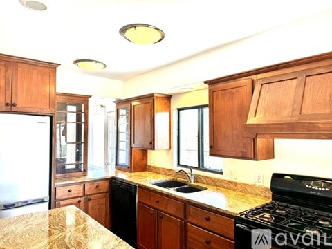 A kitchen with wooden cabinets and a granite countertop.