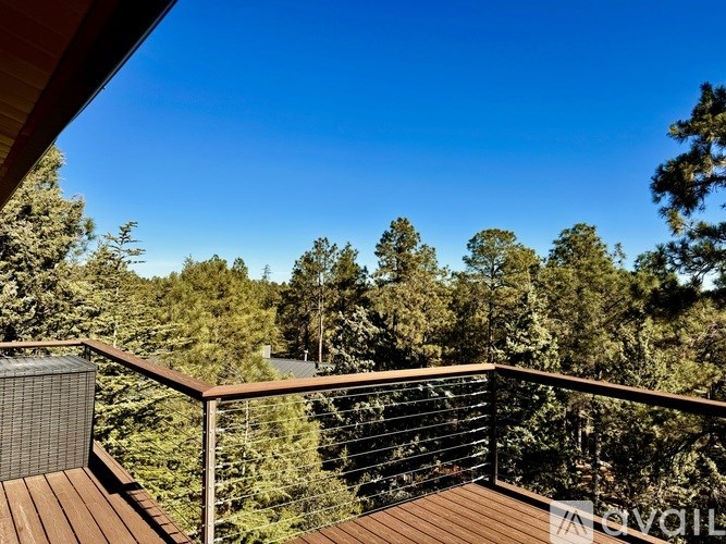A balcony with a railing overlooks a forest.