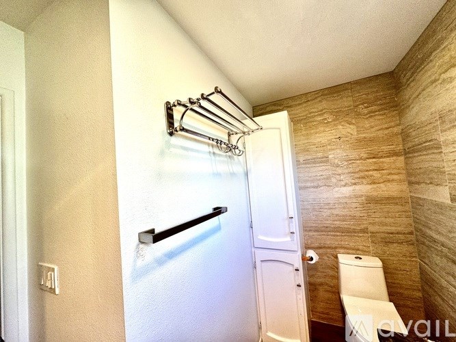 A bathroom with a towel rack and a toilet.