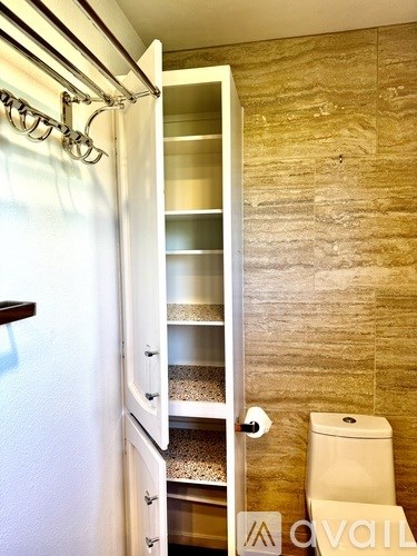 A white cabinet with a toilet in the background.