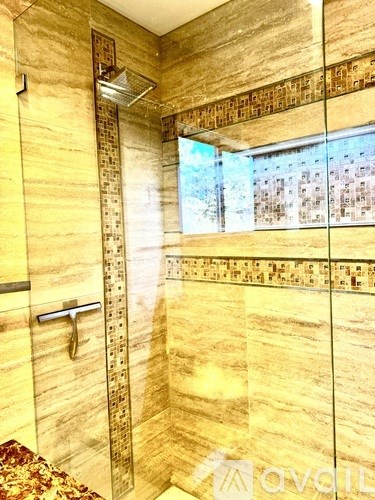 A bathroom with a walk in shower and a glass door.