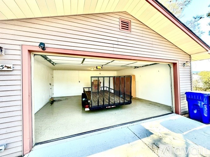A garage with a red door and a truck inside.