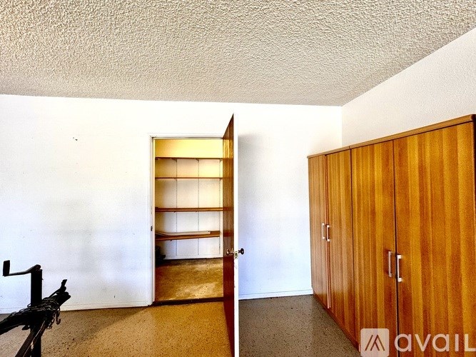 A room with a wooden cabinet and a shelving unit.