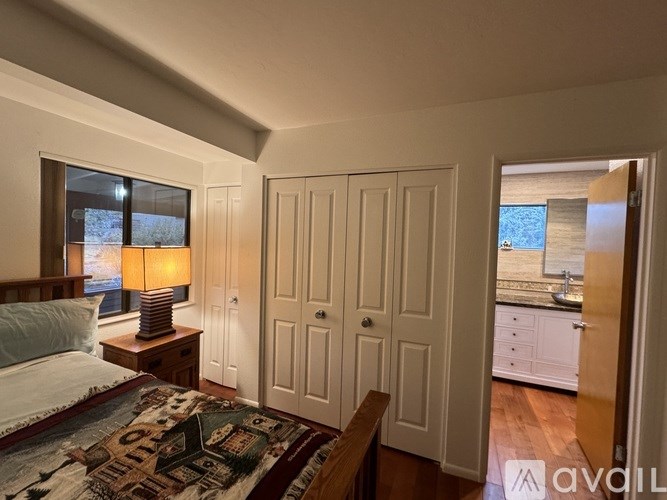 A bedroom with a bed, a lamp, and a rug.