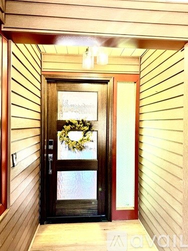 A door with a wreath on it is in a hallway.