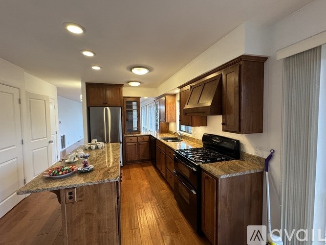 A kitchen with wooden cabinets and a granite countertop.