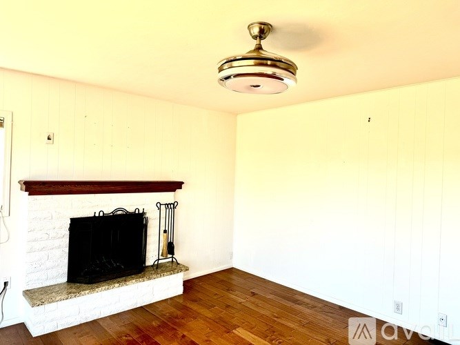 A living room with a fireplace and a light fixture.