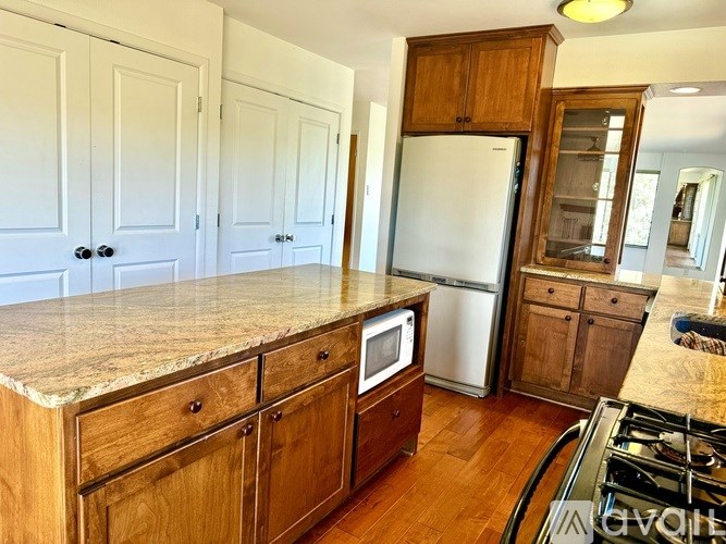 A kitchen with wooden cabinets and a marble countertop.