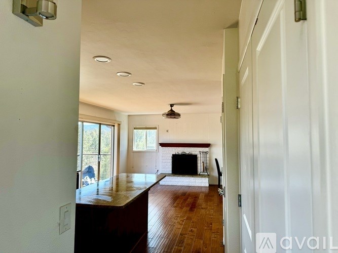 A living room with a fireplace and a ceiling fan.