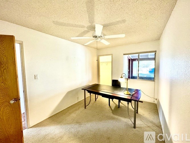 A room with a table and a ceiling fan.