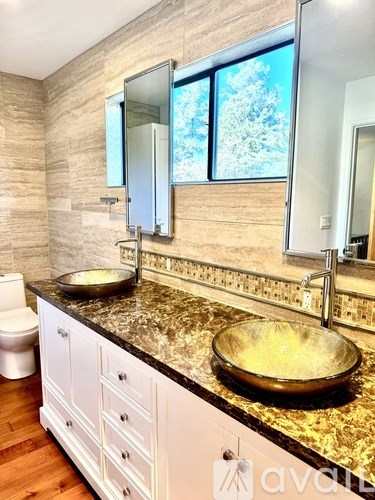 A bathroom with a granite countertop and a large mirror.