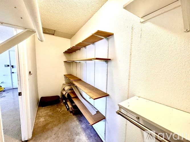 A room with a white wall and a window with blinds.