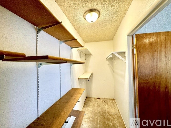 A long, narrow hallway with a bench and a door on the right.