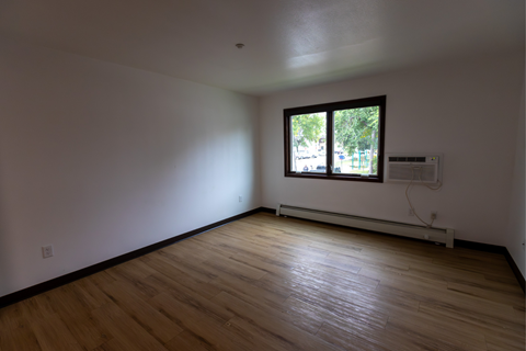 A room with wooden floors and a window.