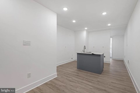 A room with a desk and a white wall.